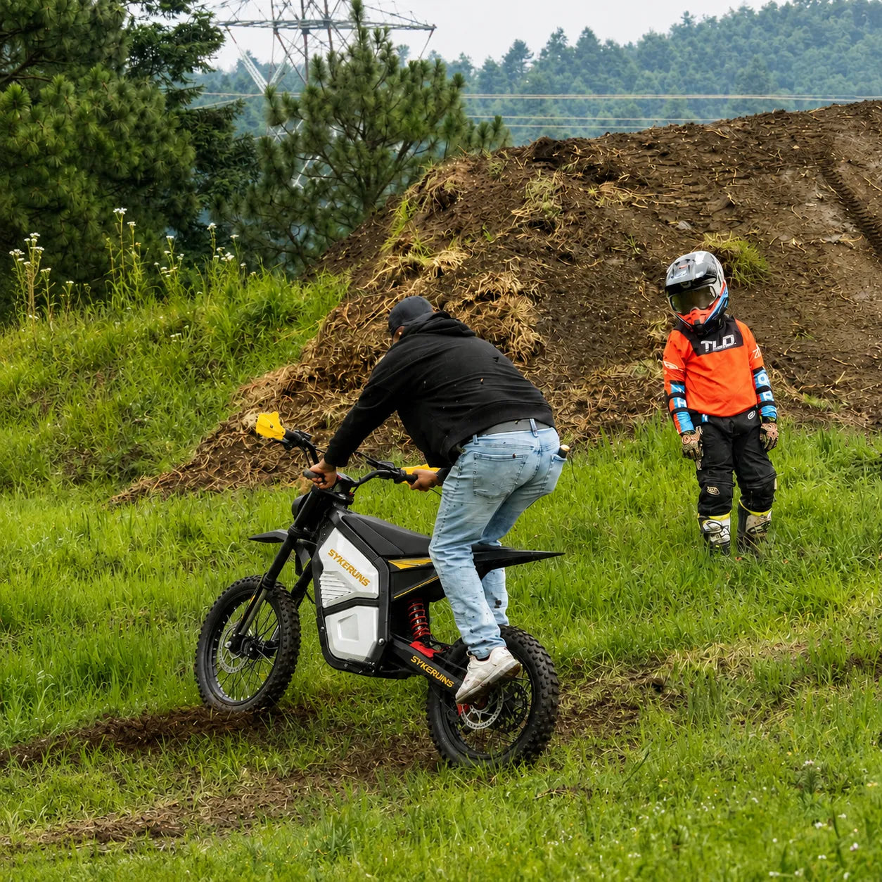 Rider testing the SYKERUNS X5 electric dirt bike on a grassy off-road trail