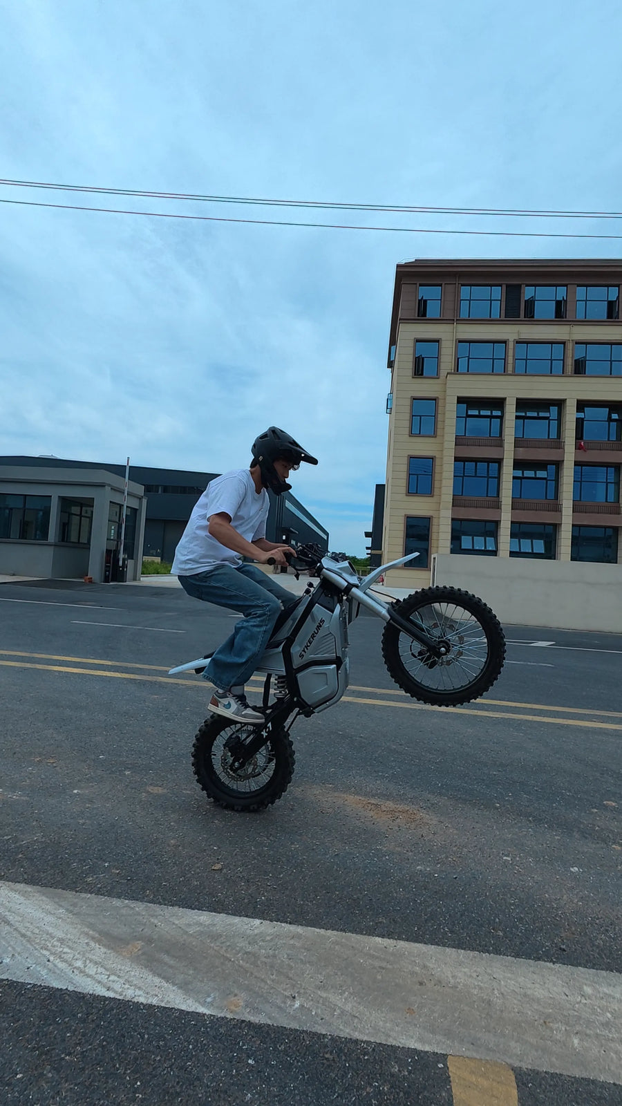 Rider performing a wheelie on a SYKERUNS X7 electric dirt bike outdoors